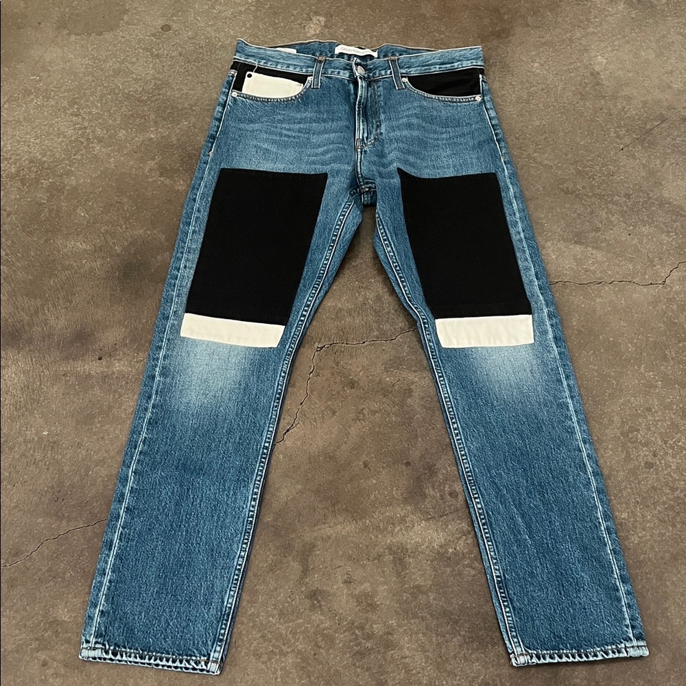 Calvin Klein Men's Blue Denim Jeans with Black & White Patch Accents